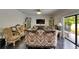The living room boasts a vintage sofa, TV, and sliding glass doors to the outdoors at 5057 Ivory Stone Dr, Wimauma, FL 33598