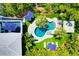 Aerial view of a kidney-shaped backyard pool surrounded by lush landscaping and patio umbrellas at 540 Gulf Bay Rd, Longboat Key, FL 34228