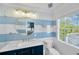 Stylish bathroom with blue and white mosaic tiles, updated fixtures, and natural light at 540 Gulf Bay Rd, Longboat Key, FL 34228