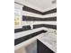 This bathroom features black and white horizontal striped walls, a marble vanity and a window at 540 Gulf Bay Rd, Longboat Key, FL 34228