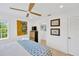 Bright bedroom featuring a ceiling fan, a bed with patterned blanket and unique art pieces at 540 Gulf Bay Rd, Longboat Key, FL 34228