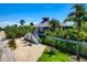 Charming two-story home with crisp white trim, complemented by lush tropical landscaping and a bright blue sky at 540 Gulf Bay Rd, Longboat Key, FL 34228