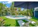 Beautiful pool surrounded by green turf and tropical plants and equipped with lounge chairs at 540 Gulf Bay Rd, Longboat Key, FL 34228