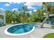 Beautiful backyard pool area featuring lounge chairs, lush tropical landscaping, and poolside bar for relaxation at 540 Gulf Bay Rd, Longboat Key, FL 34228