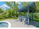 Poolside bar with stools, grill, and outdoor lighting; perfect for enjoying tropical backyard at 540 Gulf Bay Rd, Longboat Key, FL 34228
