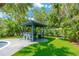 Poolside bar with grill, stools, and outdoor seating; ideal for entertaining in a lush tropical backyard at 540 Gulf Bay Rd, Longboat Key, FL 34228