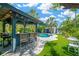 Stylish poolside bar featuring a grill, bar stools, and string lights; great for entertaining with pool views at 540 Gulf Bay Rd, Longboat Key, FL 34228