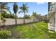 Spacious backyard featuring green grass with a white vinyl fence perfect for outdoor activities and privacy at 6024 Kipps Colony E Dr, Gulfport, FL 33707
