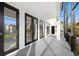 Covered balcony with black railings and black french doors, offering views of houses and greenery at 6024 Kipps Colony E Dr, Gulfport, FL 33707