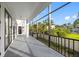 Covered balcony with black railings, offering views of the well-manicured lawn and a blue sky at 6024 Kipps Colony E Dr, Gulfport, FL 33707