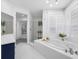 Bright bathroom features soaking tub, walk-in shower, and blue accent vanity at 6024 Kipps Colony E Dr, Gulfport, FL 33707