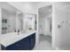 Modern bathroom featuring blue vanity with white countertops, large mirror and access to the shower and sink area at 6024 Kipps Colony E Dr, Gulfport, FL 33707
