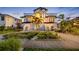 Elegant two-story home featuring lush landscaping, a symmetrical staircase entryway, and distinctive black and white accents at 6024 Kipps Colony E Dr, Gulfport, FL 33707
