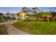 Exterior view of home showing green landscape, mature trees, and sidewalk at 6024 Kipps Colony E Dr, Gulfport, FL 33707