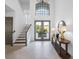 Bright foyer featuring marble floors, a staircase, high ceilings, and double doors leading to an outdoor view at 6024 Kipps Colony E Dr, Gulfport, FL 33707