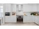 White kitchen with stainless steel appliances and a white countertop with gold decor at 6024 Kipps Colony E Dr, Gulfport, FL 33707