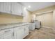 Bright laundry room featuring storage cabinets, a sink, and a washing machine at 6024 Kipps Colony E Dr, Gulfport, FL 33707