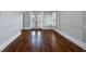 Living room featuring hardwood floors, white walls with molding and French doors that lead to the outside at 6024 Kipps Colony E Dr, Gulfport, FL 33707