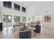 Bright living room featuring high ceilings, neutral décor, large windows, and a glimpse into the dining area at 6024 Kipps Colony E Dr, Gulfport, FL 33707