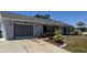 A cozy home featuring colorful landscaping, an attached garage, and a concrete driveway on a sunny day at 6405 Klaus Ct, Port Charlotte, FL 33981