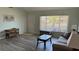 Inviting living room with stylish wood-look floors, bathed in natural light and showcasing comfortable furnishings at 6405 Klaus Ct, Port Charlotte, FL 33981