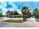Cozy single-story home with manicured lawn, brick driveway, fenced yard and a palm tree in the front at 6423 Boxwood St, Brooksville, FL 34602