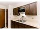 Functional kitchen featuring tile floors, a stainless steel sink, wooden cabinets and stainless appliances at 6423 Boxwood St, Brooksville, FL 34602