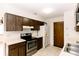 Well-lit kitchen with tile floors, wood cabinets and modern stainless steel appliances at 6423 Boxwood St, Brooksville, FL 34602