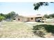 View of the home's backyard, with the patio, lawn, covered carport, and partial view of the home's exterior at 6514 La Mesa Cir, Tampa, FL 33634