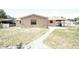 Backyard showcasing a lawn and the back of the house, leading to the carport at 6514 La Mesa Cir, Tampa, FL 33634