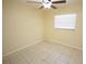 Bright bedroom features neutral tile floor, ceiling fan and window letting in natural light at 6514 La Mesa Cir, Tampa, FL 33634