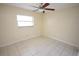 Bright bedroom features neutral tile floor, ceiling fan and window letting in natural light at 6514 La Mesa Cir, Tampa, FL 33634