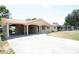 Tan single-story home has a covered carport with a long driveway and a cozy porch at 6514 La Mesa Cir, Tampa, FL 33634