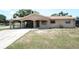 Tan single-story home features a carport, beige and rock facade, and well-lit porch at 6514 La Mesa Cir, Tampa, FL 33634