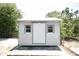 Exterior shot of shed with a door and window on either side, framed by green foliage at 6514 La Mesa Cir, Tampa, FL 33634