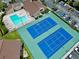 Aerial view showcasing community pool and tennis courts, plus ample parking and lush landscaping at 775 N Village N Dr # 106, St Petersburg, FL 33716