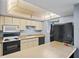 Bright kitchen featuring white cabinets, black appliances, and an island counter, perfect for meal preparation at 775 N Village N Dr # 106, St Petersburg, FL 33716