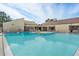 Resort-style swimming pool with sun loungers and seating area for residents to relax and enjoy the outdoors at 775 N Village N Dr # 106, St Petersburg, FL 33716
