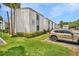 Exterior of a condo showcasing manicured landscaping, stucco walls, and a designated parking space at 776 116Th N Ave # 1110, St Petersburg, FL 33716