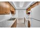 Kitchen with wooden cabinets, modern appliances, and laminate floors, with an open view to other rooms at 776 116Th N Ave # 1110, St Petersburg, FL 33716