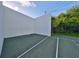 View of the racquetball court with white walls and a green floor with a treeline in the background at 776 116Th N Ave # 1110, St Petersburg, FL 33716