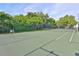 View of community tennis court and a fence with foliage behind it at 776 116Th N Ave # 1110, St Petersburg, FL 33716
