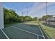 Community tennis court on a sunny day surrounded by fencing and trees at 776 116Th N Ave # 1110, St Petersburg, FL 33716