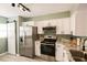 Modern kitchen featuring white cabinets, stainless steel appliances, and granite countertops at 800 Cove Cay Dr # 4F, Clearwater, FL 33760