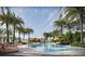 Luxurious pool surrounded by palm trees and lounge chairs with striped cushions at 805 S Gulfview Blvd # 506A, Clearwater, FL 33767