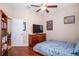Bedroom featuring hardwood floors, a ceiling fan, TV, and a bed at 8511 White Poplar Dr, Riverview, FL 33578