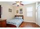 Bedroom featuring hardwood floors, a ceiling fan, a bed, and a window at 8511 White Poplar Dr, Riverview, FL 33578