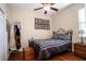 Bedroom with a ceiling fan, wood floors, and a striped comforter on the bed at 8511 White Poplar Dr, Riverview, FL 33578