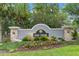 The Oak Creek community entrance featuring a stone and stucco sign surrounded by lush landscaping at 8511 White Poplar Dr, Riverview, FL 33578
