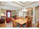 Spacious dining area featuring a large table, chandelier, and open access to the living room at 8511 White Poplar Dr, Riverview, FL 33578